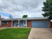 Charming single-story brick home with a blue front door and an attached garage at 912 S Kingston St, Aurora, CO 80012