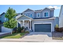Charming two-story home with a well-manicured lawn, covered porch, and a two car garage at 1173 Basalt Ridge Loop, Castle Rock, CO 80108