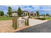 Beautiful stone home featuring a private driveway and three-car garage, all on a sprawling lawn at 5767 Pelican Shores Dr, Longmont, CO 80504