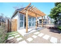 Cozy backyard patio with modern pergola, stylish glass doors, and charming stone walkway at 3735 Inca St, Denver, CO 80211