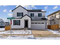 Beautiful two-story home featuring a two-car garage, and modern farmhouse design with white and gray accents at 9153 Truckee Ct, Commerce City, CO 80022