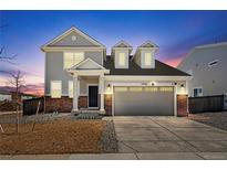 Charming two-story home with a two car garage, manicured lawn, and beautiful architectural details at sunset at 13516 Waterthrush St, Parker, CO 80134