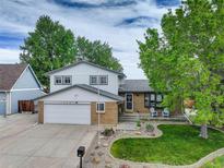 Charming two-story home boasts a well-manicured lawn, brick accents, and an attached two-car garage at 13695 W 67Th Cir, Arvada, CO 80004