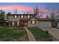 Charming two-story home boasts a well-manicured lawn, mature trees, and a welcoming entrance at 2410 S Lima St, Aurora, CO 80014