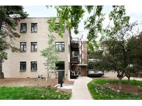 Apartment building exterior with brick facade, black windows and trees on a landscaped lot at 636 N Washington St # 301, Denver, CO 80203