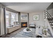Cozy living room features a fireplace and large windows at 3071 W 107Th Pl # C, Westminster, CO 80031