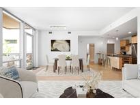 Bright living room featuring a dining area, an open floorplan, and floor-to-ceiling windows at 1401 Delgany St # 211, Denver, CO 80202