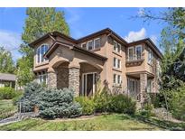 Beautiful two-story home with stone accents, stucco siding, arched entry and landscaped front yard at 8053 E Maple Ave, Denver, CO 80230