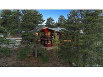 Stunning multi-story home nestled amongst tall trees, with a cozy and inviting mountain ambiance at 25392 Westridge Rd, Golden, CO 80403
