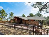 Charming single-story home featuring stone accents, a covered porch, and well-kept landscaping at 25392 Westridge Rd, Golden, CO 80403