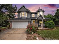 Charming two-story home boasts a unique turret, stone accents, well-manicured lawn, and an attached two-car garage at 5491 S Youngfield W Ct, Littleton, CO 80127