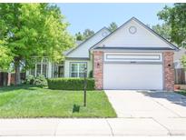 Charming single-Gathering home featuring a well-manicured lawn, brick accents, and a two-car garage at 19249 E Progress Ave, Centennial, CO 80015