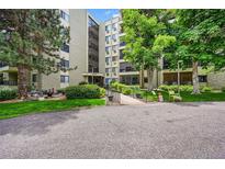 Apartment building exterior featuring a well-manicured lawn and mature shade trees at 13890 E Marina Dr # 304, Aurora, CO 80014