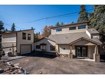 Charming two-story home with neutral siding, a separate garage and mature trees at 5571 Little Cub Creek Rd, Evergreen, CO 80439
