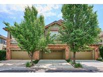 Charming townhome featuring a brick facade, attached garages, and mature trees at 10134 Bluffmont Ln, Lone Tree, CO 80124