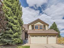 Charming two-story home with a well-manicured lawn, mature trees, and a three-car garage at 9412 La Quinta Way, Lone Tree, CO 80124