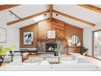 Inviting living room with stone fireplace, wood beams, and stylish decor, perfect for cozy gatherings at 7045 S Penrose Ct, Centennial, CO 80122