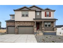 Beautiful two-story home with stone accents, gray siding, a covered porch, and a three-car garage at 1667 Fox Trotter Pt, Castle Rock, CO 80104