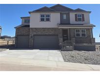 Beautiful two-story home with a stone facade and a three-car garage at 1667 Fox Trotter Pt, Castle Rock, CO 80104