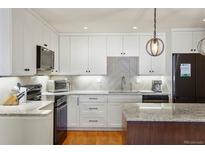 Bright kitchen with white cabinetry, stainless appliances, and granite countertops at 7192 S Vine E Cir, Centennial, CO 80122