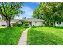 Charming single-story home featuring a well-manicured lawn, mature trees, and inviting curb appeal at 1935 Oneida St, Denver, CO 80220