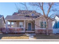 Charming home with inviting front porch, blue door with a wreath, and nicely landscaped front yard at 4315 Bella Vista Dr, Longmont, CO 80503
