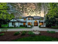 Elegant two-story home with lush landscaping, circular driveway, and prominent architectural details at 5345 S Race Ct, Greenwood Village, CO 80121