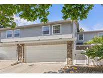 Charming townhome featuring stone accents, a spacious two-car garage, and a well-maintained front yard at 2742 S Xanadu Way, Aurora, CO 80014