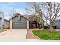Charming home featuring a spacious front yard with mature trees and a two-car garage at 5421 S Vivian St, Littleton, CO 80127