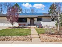 Charming single-story home featuring solar panels, a well-maintained lawn, and a welcoming entrance at 13905 W 21St Ave, Golden, CO 80401