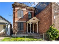 Charming brick home featuring a well-maintained front yard and a welcoming arched entryway at 2318 Arapahoe St, Denver, CO 80205