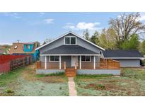 Charming home featuring a cozy front porch, complemented by a well-maintained yard and classic architectural details at 400 Division Blvd, Platteville, CO 80651