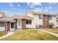 Charming townhouse featuring a well-manicured lawn and inviting front porch, perfect for enjoying the outdoors at 961 S Miller Way, Lakewood, CO 80226