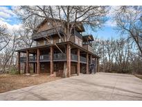 Stunning three-story home with multiple balconies and a large tree integrated into the design at 9350 W Florida Ave, Lakewood, CO 80232