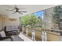 Relaxing balcony space with seating and ceiling fan overlooking green outdoor view at 800 N Washington St # 307, Denver, CO 80203