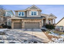 Two-story house with stone accents, two-car garage, and a landscaped yard at 1575 Ridgetrail Ct, Castle Rock, CO 80104