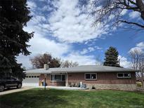 Charming brick ranch-style home with well-maintained lawn and attached two-car garage at 12375 W 19Th Pl, Lakewood, CO 80215