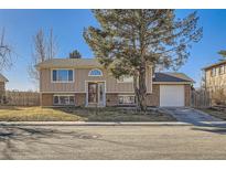 Charming two-story home with a well-maintained lawn and mature landscaping, creating inviting curb appeal at 8556 W Arbor Pl, Littleton, CO 80123