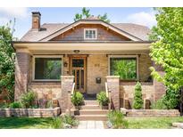 Charming brick home featuring a covered porch, well-maintained landscaping, and inviting curb appeal at 315 S Franklin St, Denver, CO 80209