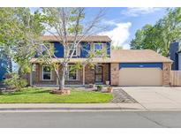 Charming two-story home featuring a brick and blue exterior with a well-manicured lawn and a cozy covered front porch at 3238 W 11Th Avenue Pl, Broomfield, CO 80020