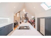 Bright kitchen features a large island with cooktop, pendant lighting, and an open layout with easy access to dining and living areas at 1165 N Pennsylvania St # 3B, Denver, CO 80203