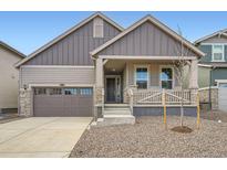 Charming home featuring a stone-accented front porch and a two-car garage at 24732 E Atlantic Dr, Aurora, CO 80018