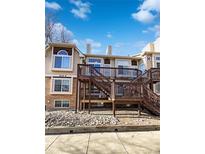 Exterior view of building featuring private deck with stairs and a combination of siding and brick facade at 1885 S Quebec Way # H27, Denver, CO 80231