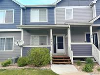 Charming multi-level home featuring a covered entryway and a mix of blue and grey siding at 19246 E Idaho Pl # 102, Aurora, CO 80017