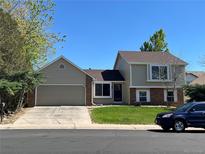 Charming two-story home with a manicured lawn and an attached two-car garage at 15962 E Exposition Dr, Aurora, CO 80017