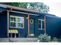 Inviting home entrance with a charming wreath, bench seating, and dark blue painted siding at 332 Maple Dr, Frederick, CO 80530