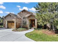 Charming home featuring a stone-accented entrance, arched doorway, and a well-manicured front yard at 5055 Mcclure Ln, Castle Rock, CO 80108