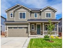 Charming two-story home with a manicured lawn, attached two car garage, and beautiful curb appeal at 821 Boulder Peak Ave, Erie, CO 80516