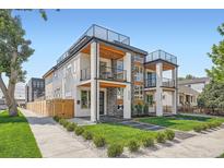 Contemporary home boasts multi-level outdoor decks and modern design with stone accents and manicured landscaping at 2599 S Cherokee St, Denver, CO 80223