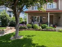 Well-maintained front yard with lush green lawn, landscaping, and charming brick home exterior at 4907 Fenwood Dr, Highlands Ranch, CO 80130